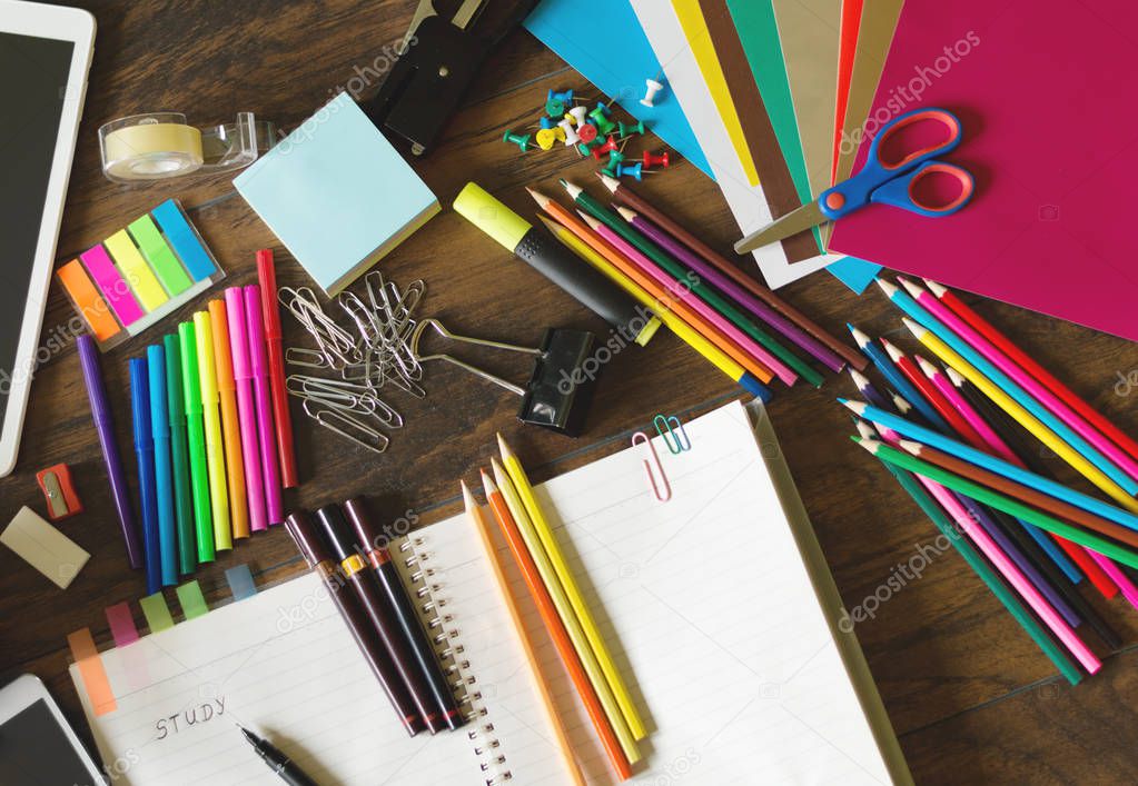 Colorful assortment of school supplies on table.