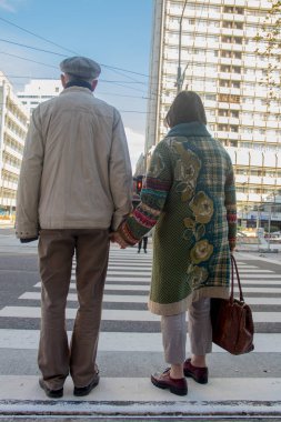Son sınıflar el ele tutuşuyor, büyük anne ve büyük baba karşıdan karşıya geçiyor.