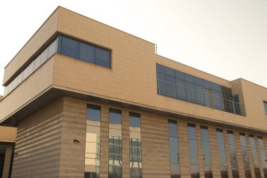 Şehir metropolü modern mimarisi. Dışarısı cam duvarlarla kaplı, etrafındaki binaları yansıtıyor. İş ve ofis amaçları için yepyeni binalar