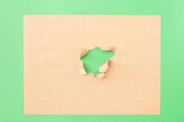 Yeşil üzerinde delik olan el işi sayfası — Stok fotoğraf
