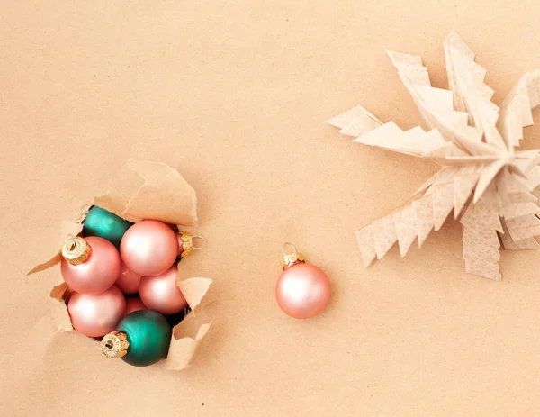 穴のあるクラフト紙の背景にクリスマスの装飾ボール — ストック写真