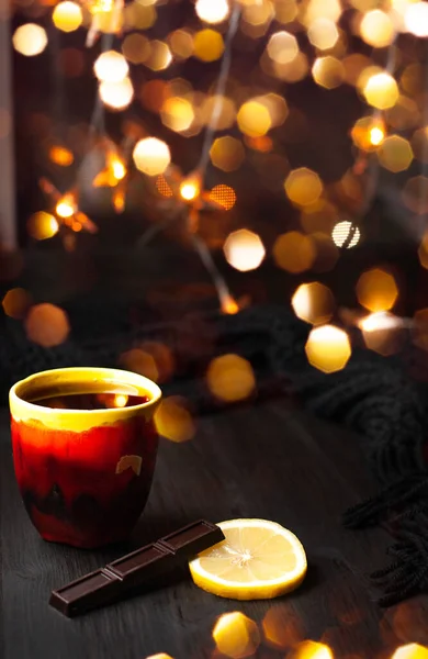 Una taza de té de cerámica sobre fondo oscuro con luces de Navidad —  Fotos de Stock