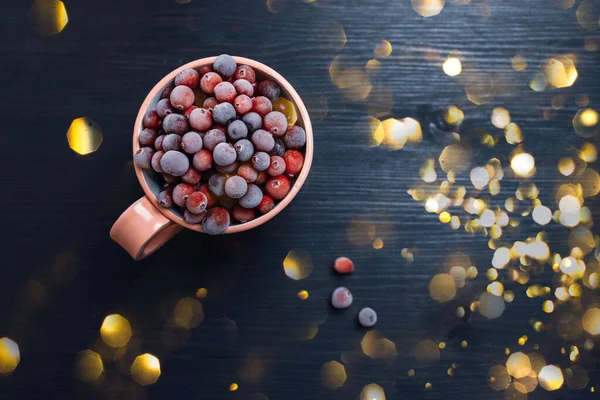 Coppa con bacche fresche congelate su sfondo scuro — Foto Stock