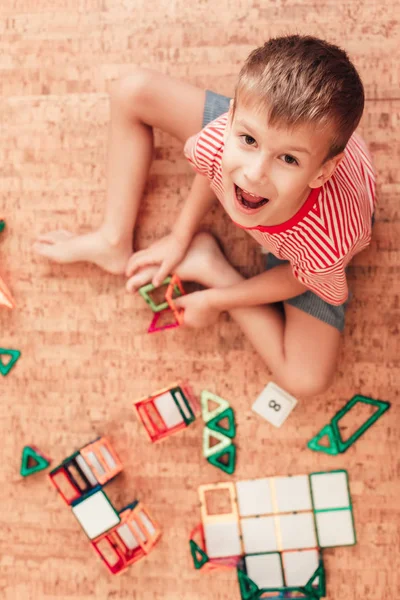 Happy boy bermain dengan konstruktor magnetik di lantai Stok Gambar Bebas Royalti