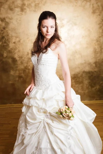 Mulher de cabelos escuros bonita em vestido de noiva branco — Fotografia de Stock