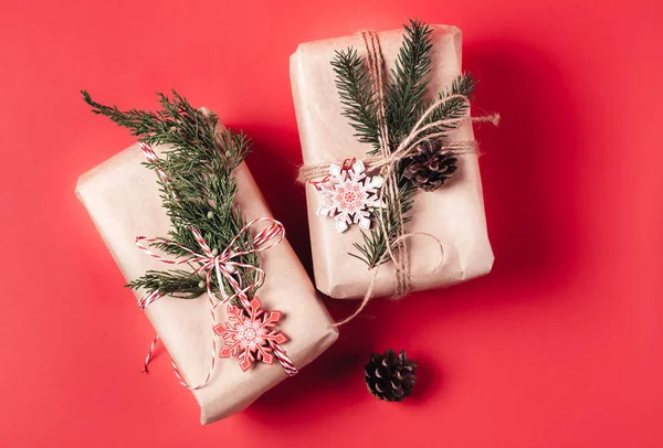 Schöne Geschenkschachtel in Bastelpapier auf rotem Papier Hintergrund verpackt — Stockfoto
