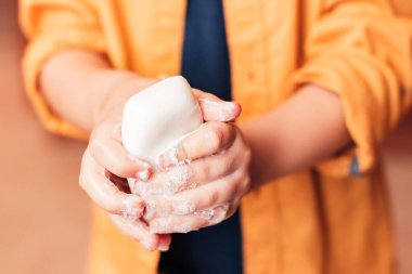 Çocuk ellerini sabunla yıkıyor, yakın plan, yüzsüz.