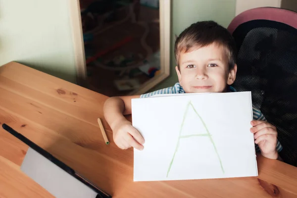 Tevreden jongen toont pagina met schriftelijke brief A — Stockfoto