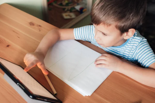 Modern kind gebruikt app op tablet om thuis te studeren en te tekenen — Stockfoto