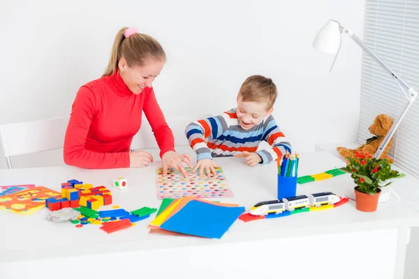 Peuter jongen spelen in bordspel met zijn moeder — Stockfoto