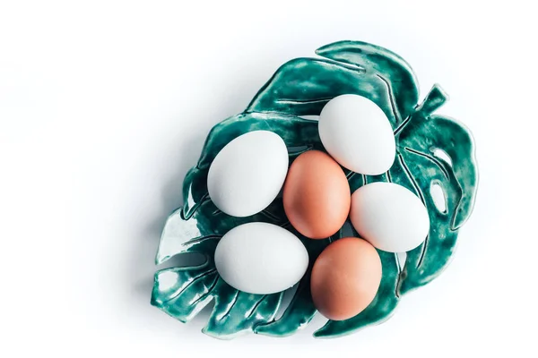 Несколько куриных яиц лежат на керамической тарелке — стоковое фото