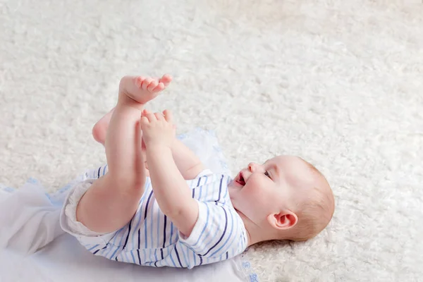 Smiling Baby Boy Plaing His Legs While Laying Bed — Stock Photo, Image