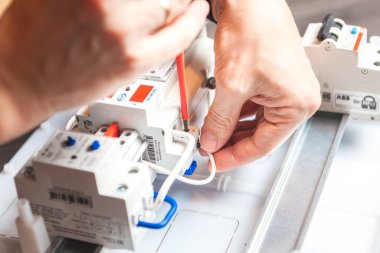 Erkeklerin elleri yakın plan. Kabloyu temizliyorum. Elektrik sayacının kurulumu.