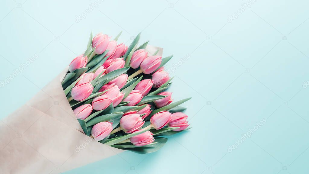 Beautiful bouquet of pink tulips on light blue background