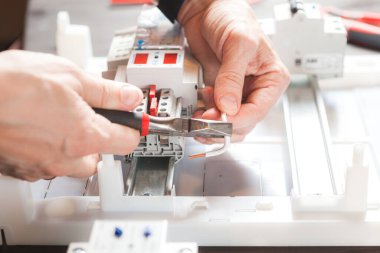 Erkeklerin elleri yakın plan. Elektrik sayacı kurulumu. Kabloyu temizleyen adam