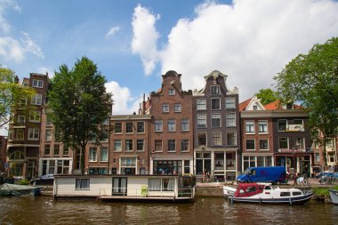 Amsterdam - 10 Temmuz 2016: geleneksel Hollanda evleri tarafından çevrelenmiş Amsterdam kanalları şehir.