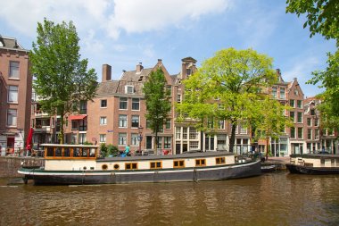 Amsterdam - 10 Temmuz 2016: geleneksel Hollanda evleri tarafından çevrelenmiş Amsterdam kanalları şehir.