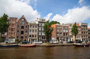 Amsterdam - 10 Temmuz 2016: geleneksel Hollanda evleri tarafından çevrelenmiş Amsterdam kanalları şehir.