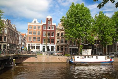 Amsterdam - 10 Temmuz 2016: geleneksel Hollanda evleri tarafından çevrelenmiş Amsterdam kanalları şehir.