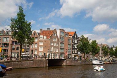Amsterdam - 10 Temmuz 2016: geleneksel Hollanda evleri tarafından çevrelenmiş Amsterdam kanalları şehir.