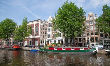 Amsterdam - 10 Temmuz 2016: geleneksel Hollanda evleri tarafından çevrelenmiş Amsterdam kanalları şehir.