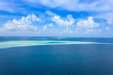 Maldivler 'de küçük bir ada. Palmiyelerle kaplı ve turkuvaz mavisi sularla çevrili. Güzel mercanları ve hayvanları var.