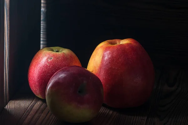 Красные яблоки на темном деревенском столе — стоковое фото