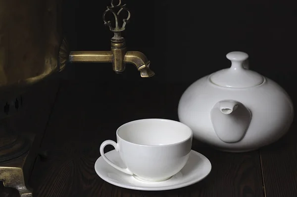 Csésze tea, teáskanna és a sötét háttéren samovar. — Stock Fotó