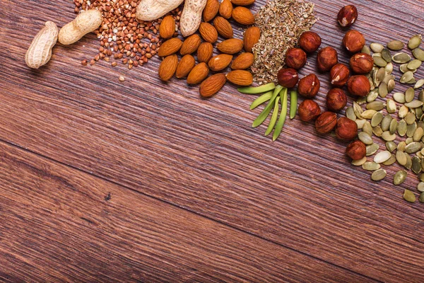 Surtido de frutos secos en tazón blanco, plato en la superficie de madera. Vista superior con espacio de copia — Foto de Stock