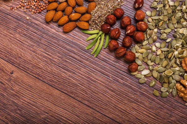 Surtido de frutos secos en tazón blanco, plato en la superficie de madera. Vista superior con espacio de copia — Foto de Stock