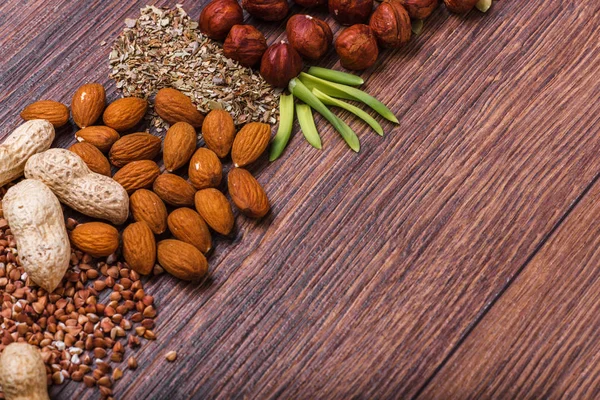 Surtido de frutos secos en tazón blanco, plato en la superficie de madera. Vista superior con espacio de copia — Foto de Stock