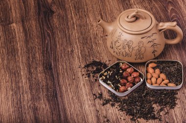 Ahşap bir yüzey üzerinde çay çay süzgeci. Yeşil ve siyah çay Top kopya alanı görünümüyle