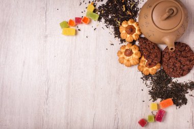 Çay bir ahşap yüzeyde bileşimi. kahverengi demlik çay, badem ve fındık bir saçılma ile Clay. Yeşil, siyah çay. Tanımlama bilgileri ve sakızlı şeker. Kopya alanı ile Üstten Görünüm.