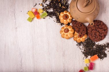 Çay bir ahşap yüzeyde bileşimi. kahverengi demlik çay, badem ve fındık bir saçılma ile Clay. Yeşil, siyah çay. Tanımlama bilgileri ve sakızlı şeker. Kopya alanı ile Üstten Görünüm.