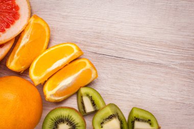 limon, portakal, kivi, greyfurt, mandalina ahşap bir yüzey üzerinde. dilimlenmiş meyve tanzimi. Metin kopyalama yeri olan Üstten Görünüm