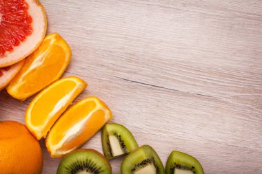 limon, portakal, kivi, greyfurt, mandalina ahşap bir yüzey üzerinde. dilimlenmiş meyve tanzimi. Metin kopyalama yeri olan Üstten Görünüm