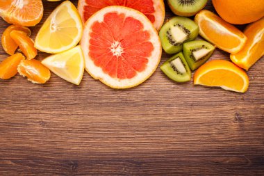limon, portakal, kivi, greyfurt, mandalina ahşap bir yüzey üzerinde. dilimlenmiş meyve tanzimi. Metin kopyalama yeri olan Üstten Görünüm