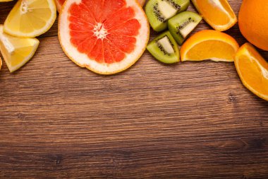 limon, portakal, kivi, greyfurt, mandalina ahşap bir yüzey üzerinde. dilimlenmiş meyve tanzimi. Metin kopyalama yeri olan Üstten Görünüm