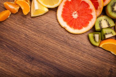 limon, portakal, kivi, greyfurt, mandalina ahşap bir yüzey üzerinde. dilimlenmiş meyve tanzimi. Metin kopyalama yeri olan Üstten Görünüm