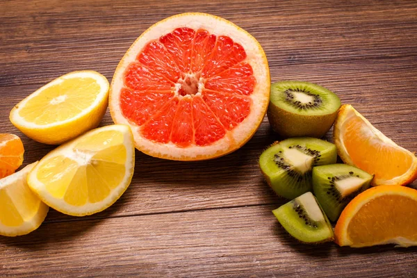 레몬, 오렌지, 키 위, 자 몽, 만다린 나무 표면에. 얇게 썬된 과일의 배열입니다. 텍스트 복사 공간 평면도 — 스톡 사진