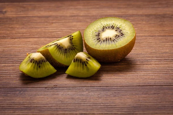 Kiwi on a wooden surface. arrangement of sliced fruit. — Stock Photo, Image