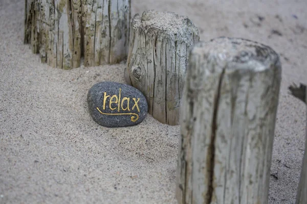 Rilassarsi Lettering su ghiaia sulla spiaggia di sabbia — Foto Stock