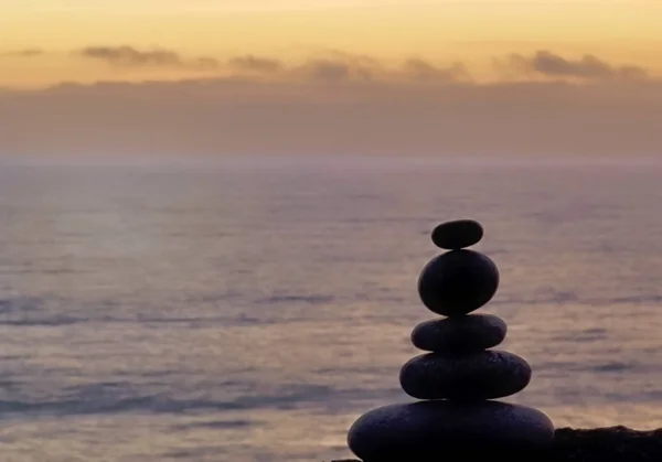 Stone Cairn à la plage au coucher du soleil — Photo