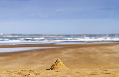 İspanya 'da yalnız bir plajda çocuklar tarafından yapılmış kum tepesi.
