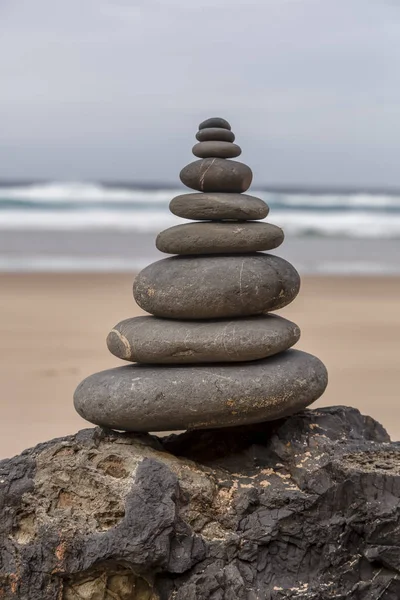 well balanced stone cairn on a lonely beach at the wild west coast of the portuguese algarve