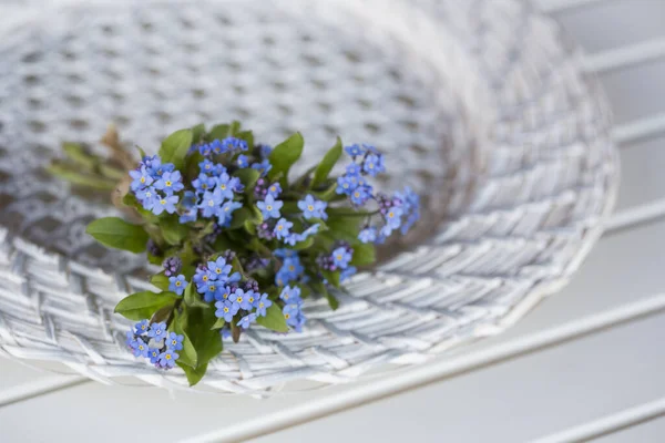 Blue Forget Me Not Flowers on Wicker Teller — Stockfoto
