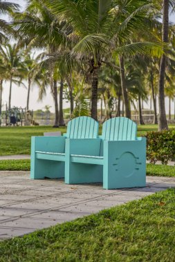 Ocean Drive ile Miami Sahili arasında renkli ahşap koltuklar.