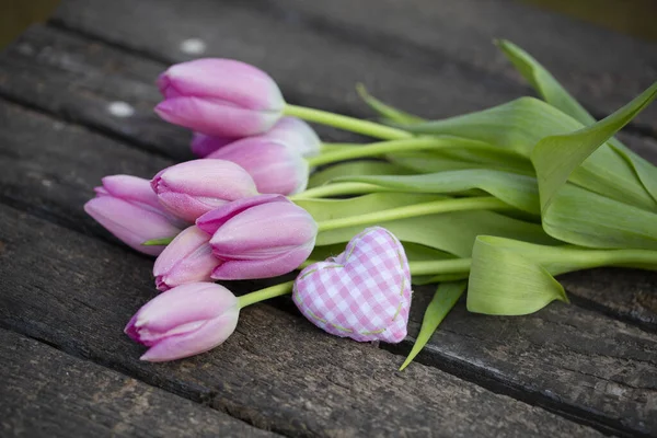 新鲜的粉红郁金香花和小小的粉色格子花心放在苦恼的木制桌子上 非常适合做贺卡 礼品盒或日历 — 图库照片
