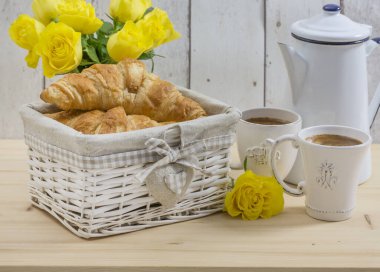 Kıtasal Euopean tarzı aperatifli klasik masa seti ya da sarı güllü kahvaltı, diş minesi tenceresi, kruvasan ve sıcak içecek.