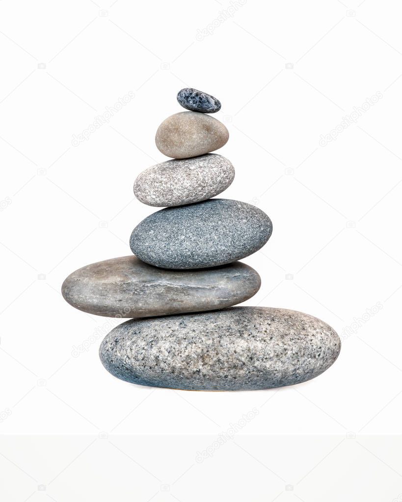 Balanced pebble stone cairn across a white background
